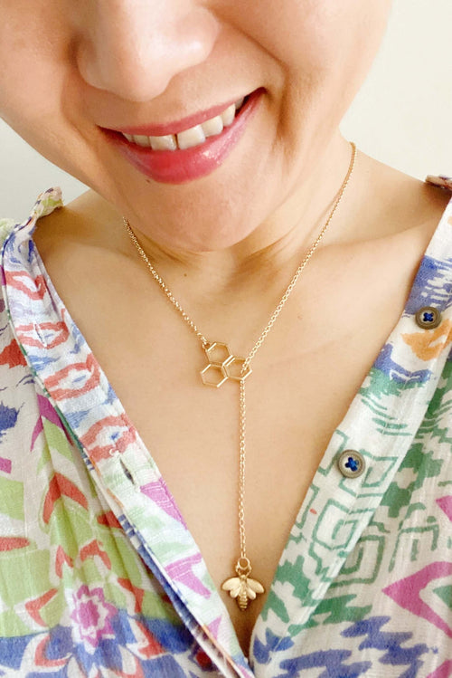 Bee Necklace Gold worn on a woman, featuring a delicate bee pendant and honeycomb design, symbolic of love and connection.